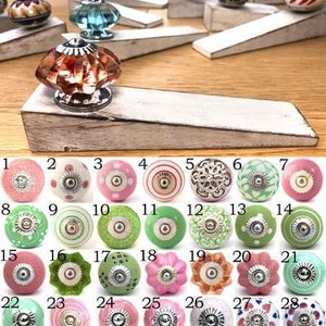 May include: Assortment of 28 ceramic knobs in various colours and patterns, including pink, green, white, and brown. The knobs have a variety of designs, including polka dots, stripes, and floral patterns.