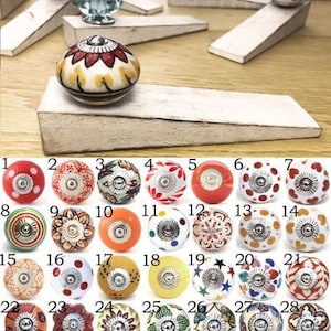 May include: Assortment of 28 ceramic door knobs with various colourful patterns and designs. The knobs are round and have a silver metal base.