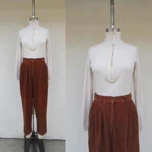 May include: A white ribbed turtleneck sweater with a zipper and brown corduroy pants.