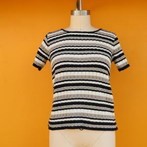 May include: A black and white striped short-sleeved shirt with a ribbed texture.