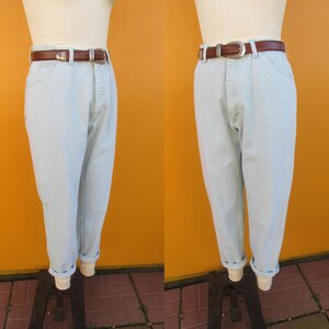 Op de afbeelding: Lichtblauwe denim jeans met een bruine leren riem. De jeans hebben een relaxte pasvorm en zijn aan de onderkant gezoomd.