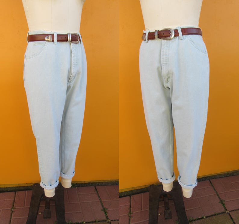Op de afbeelding: Lichtblauwe denim jeans met een bruine leren riem. De jeans hebben een relaxte pasvorm en zijn aan de onderkant gezoomd.