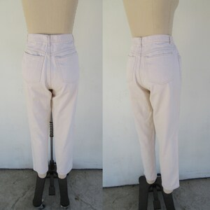 Puede incluir: Un par de pantalones vaqueros de color beige claro de cintura alta con pierna recta.