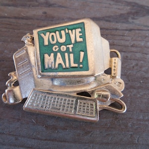 May include: Gold-tone metal pin shaped like a computer with a green screen that says "You've Got Mail!"
