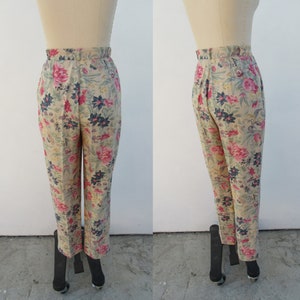 May include: Beige high-waisted pants with a floral print featuring pink, red, and blue flowers.
