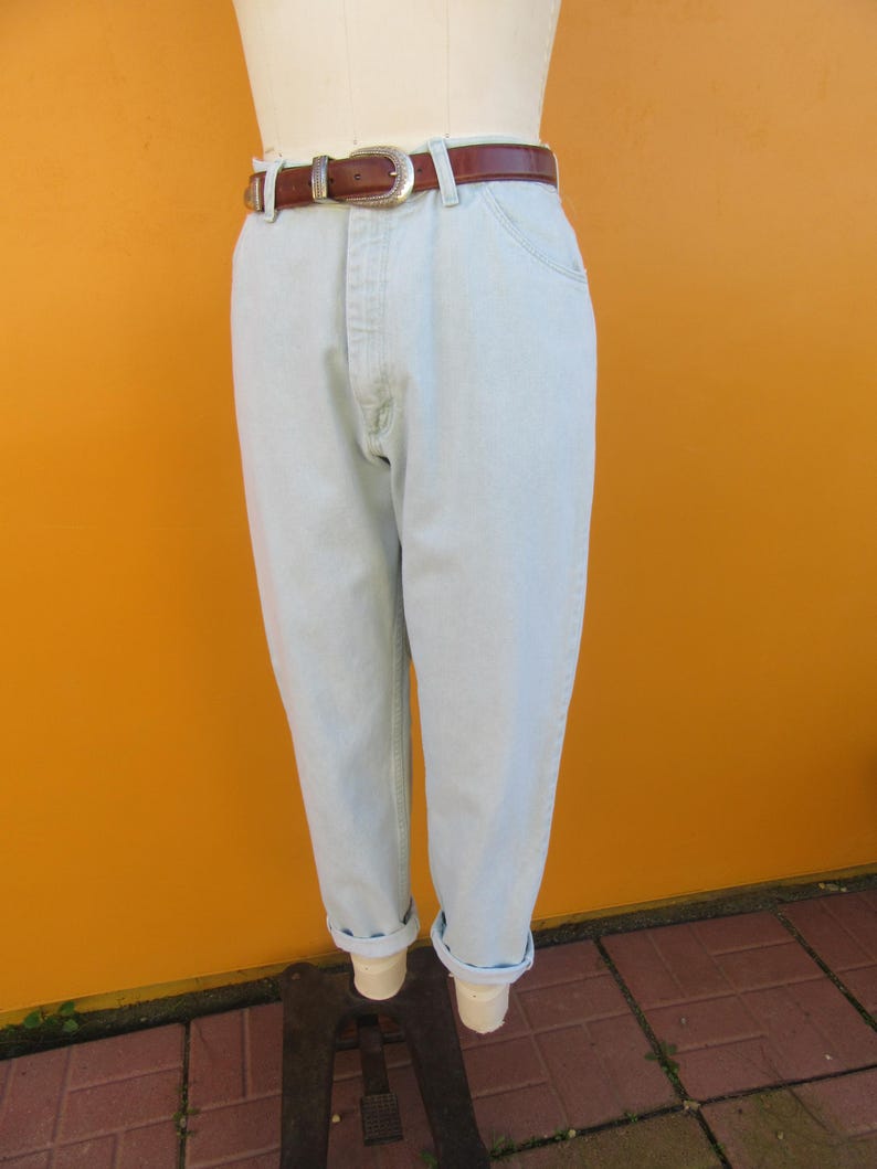 Op de afbeelding: Lichtblauwe denim jeans met een bruine leren riem. De jeans hebben een hoge taille en een ontspannen pasvorm.