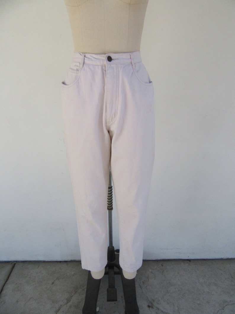 Puede incluir: Un par de pantalones vaqueros de color rosa claro de cintura alta. Los vaqueros tienen una pierna recta y est&aacute;n hechos de una tela suave y c&oacute;moda.