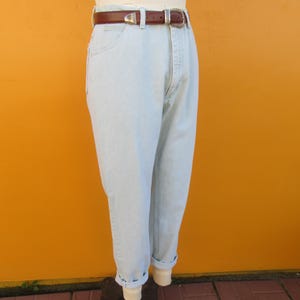 Op de afbeelding: Lichtblauwe denim jeans met een bruine leren riem. De jeans heeft een relaxte pasvorm en is aan de onderkant gecuffed.