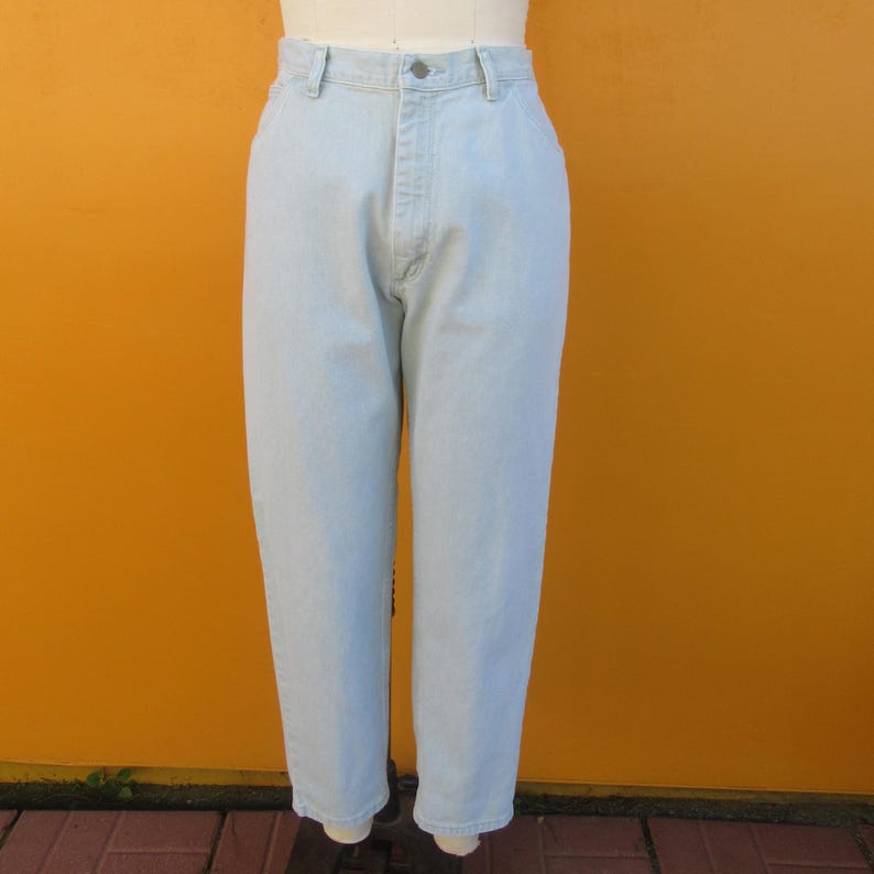 Op de afbeelding: Lichtblauwe spijkerbroek met een rechte pijp. De broek heeft een knoopsluiting en riemlussen.