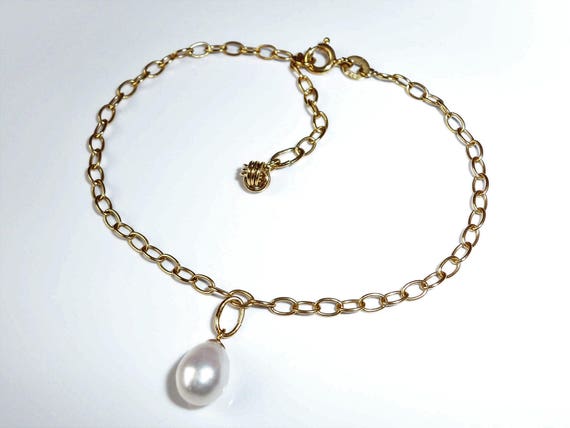 A 9CT GOLD CHARM BRACELET WITH A MIX OF 9ct, 14ct AND 18ct GOLD CHARMS  WEIGHS 23.7g- APPROXIMATELY 1