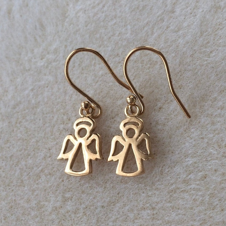 以下が含まれることがあります： シンプルなデザインの金の天使の形をしたイヤリングのペア。イヤリングはフック留めです。