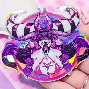 May include: A holographic sticker featuring a purple and pink demon with black and white striped horns, wearing a pink bikini top with a pentagram. The demon has long purple hair and is surrounded by a pink and purple circle with a pentagram.