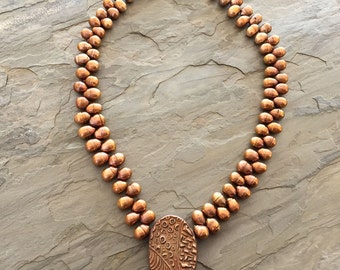 Colgante Oval hueco cobre con perlas bronce
