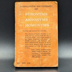 May include: Vintage Scholastic Dictionary of Synonyms, Antonyms, and Homonyms. The cover is orange with white text. The book promises to help with writing and speaking. The price is 45 cents.