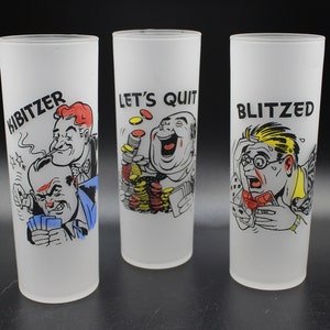 May include: Three frosted glass tumblers with cartoon illustrations and text. One tumbler reads "KIBITZER" with a drawing of men playing cards. Another says "LET'S QUIT" with a man surrounded by coins. The third says "BLITZED" with a stressed man.