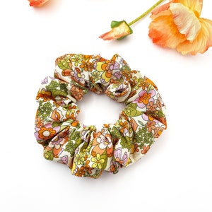 A retro floral scrunchie with a warm color palette and vintage-inspired design.