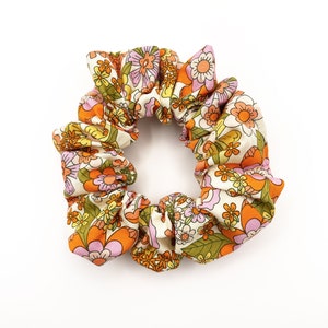 A retro floral scrunchie with a warm color palette and vintage-inspired design.