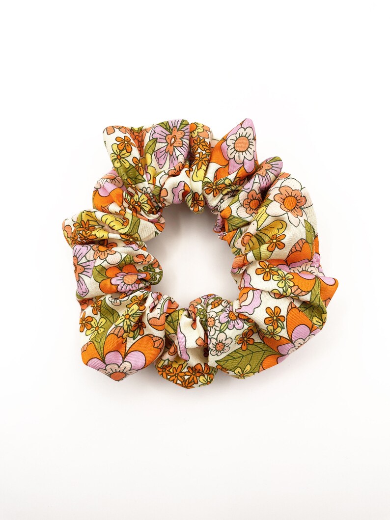 A retro floral scrunchie with a warm color palette and vintage-inspired design.