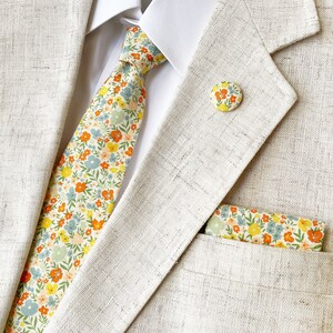 A handmade floral necktie with a small ditsy flower print with a matching pocket square (sold separately).