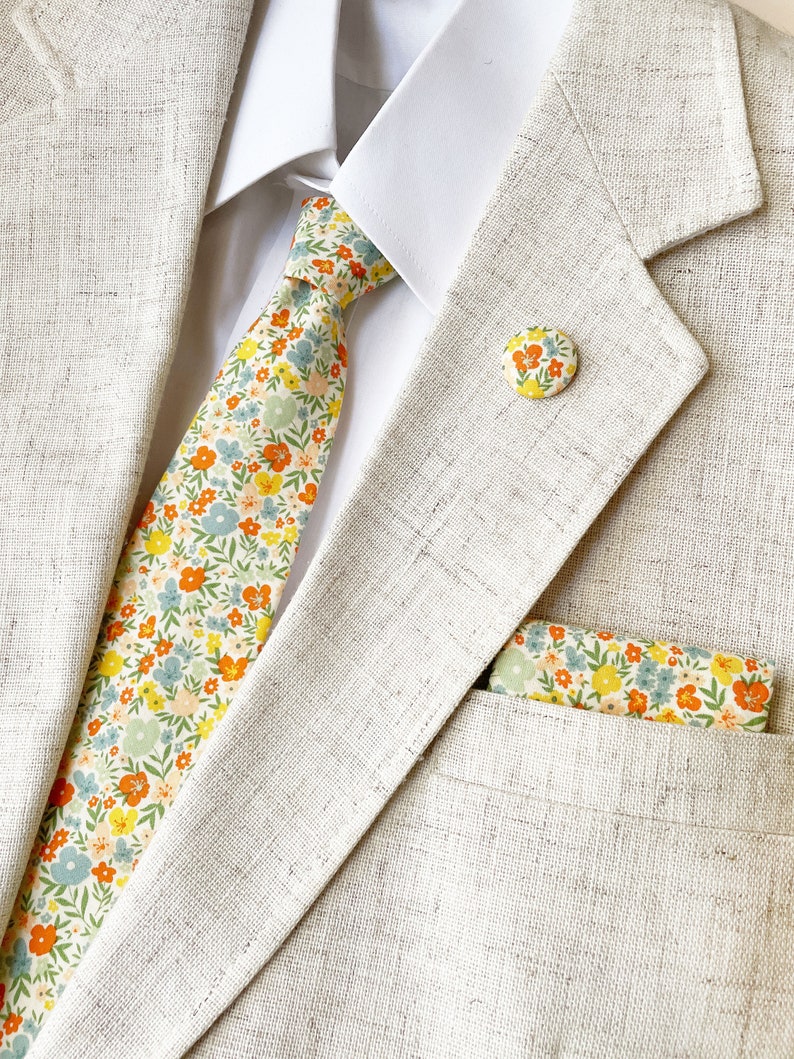 A handmade floral necktie with a small ditsy flower print with a matching pocket square (sold separately).