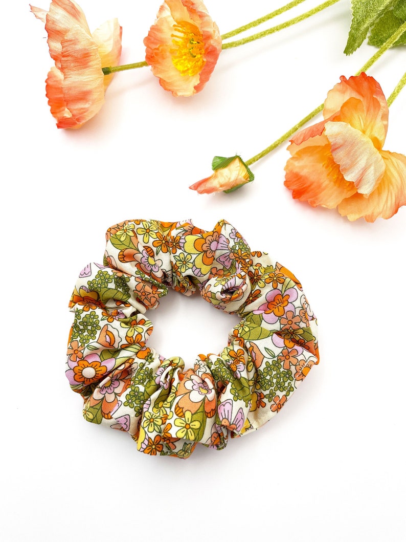 A retro floral scrunchie with a warm color palette and vintage-inspired design.