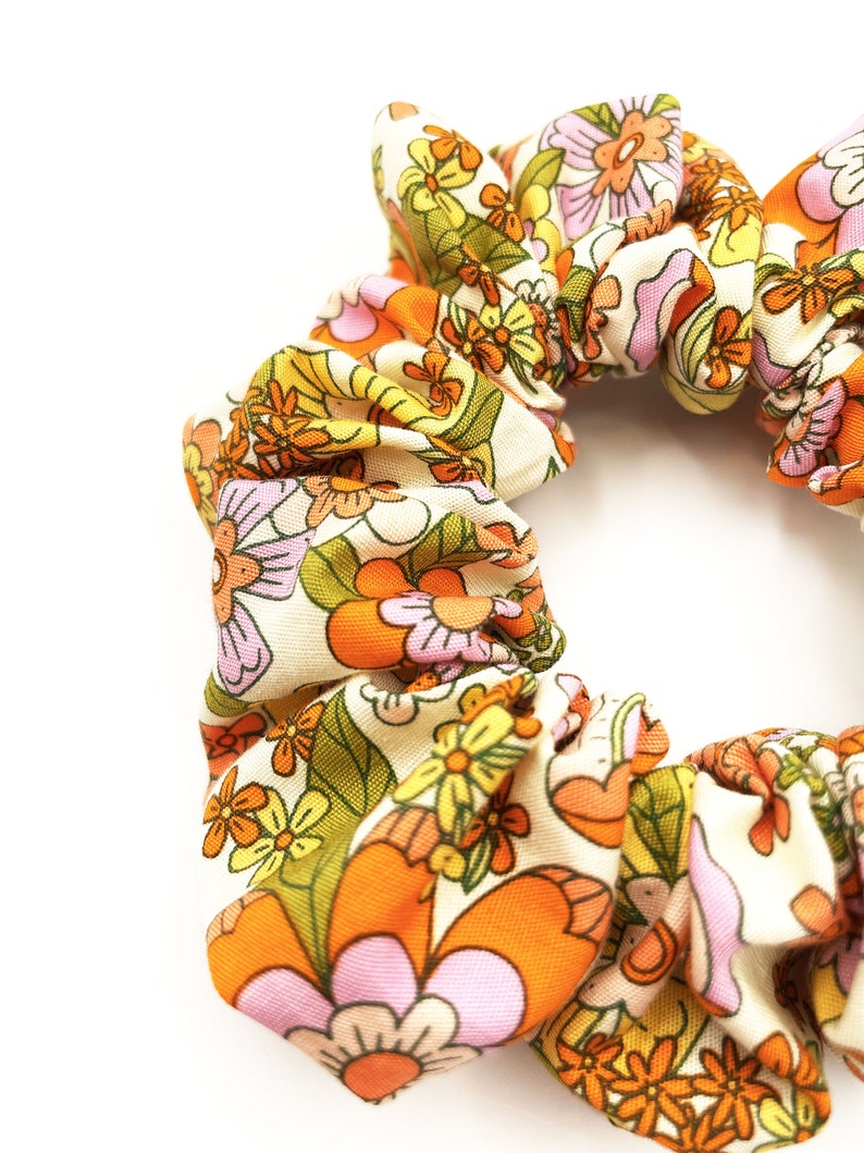 A retro floral scrunchie with a warm color palette and vintage-inspired design.