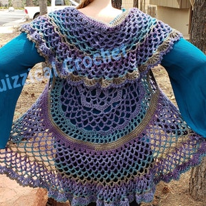 May include: A crocheted vest with a mandala design in shades of purple, blue, and green. The vest has a wide, flowing shape and a scalloped hem.