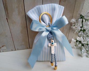 May include: A small blue and white striped fabric bag with a blue ribbon tied around it. The bag has a gold ring attached to it with a white cross charm with a blue evil eye on it.