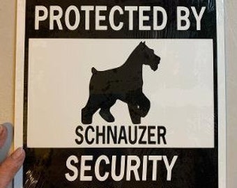 May include: Black and white sign with the text "This property protected by Schnauzer Security System". A black silhouette of a Schnauzer dog is in the center of the sign.
