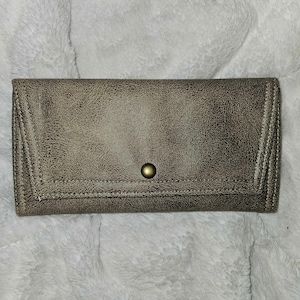 May include: A brown leather wallet with a gold button closure.