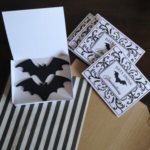 May include: A set of printable Halloween party decorations featuring a black and white design with bats and the text "Bats Drink Decorations".