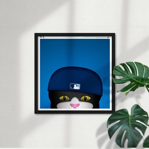 May include: A black cat wearing a blue baseball cap with a white baseball logo. The cat's eyes are yellow and the cat has a pink nose.
