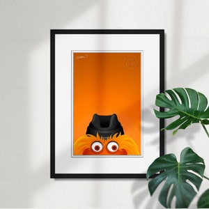 May include: A framed illustration of a cartoon character with orange fur, black eyes, and a black hat. The character's eyes are wide open and staring directly at the viewer. The background is a solid orange color.