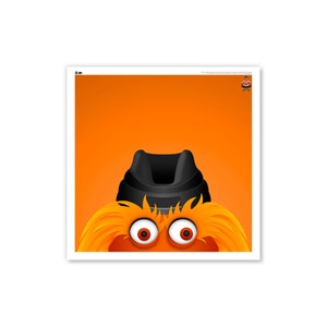 May include: A close-up of a fuzzy orange mascot with black eyes and a black hat. The mascot's eyes are wide open and staring directly at the viewer.