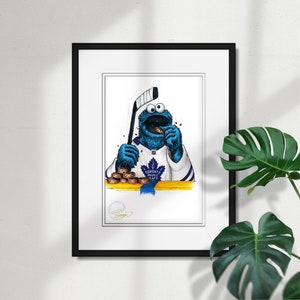 May include: An illustration of Cookie Monster wearing a Toronto Maple Leafs hockey jersey and holding a hockey stick. He is eating a cookie and there are cookies on the table in front of him.