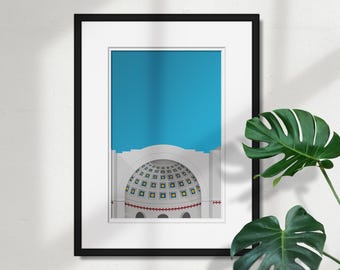May include: A framed print of a white building with a blue sky in the background. The building has a large, round dome with a pattern of blue and yellow squares. The dome is surrounded by a white archway.