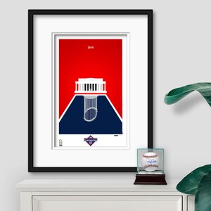 Puede incluir: Una impresi&oacute;n enmarcada de un estadio de b&eacute;isbol con un esquema de color rojo, blanco y azul. El estadio se representa como una silueta con un trofeo de b&eacute;isbol en el centro. El texto "2019" y "CHAMPIONS" es visible en la impresi&oacute;n.
