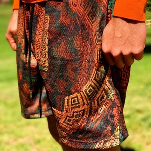 May include: A pair of black and orange athletic shorts with a geometric pattern. The shorts have a drawstring waist and a mesh fabric.