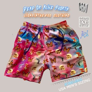 Pu&ograve; includere: Shorts in tie-dye rosa, blu e bianco con stampa di teschio, farfalla e fungo. I pantaloncini hanno una vita con coulisse e sono lunghi fino al ginocchio. Il testo "Dead or Alive Shorts" e "Lionsinthezoo Clothing" &egrave; stampato sull'immagine.
