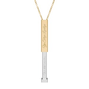 Könnte beinhalten: Goldfarbene Anhängerkette mit rechteckigem Stabdesign. Der obere Teil des Stabs trägt den eingravierten Text "Ya Tebya Lyublyu". Der untere Teil ist silberfarben und trägt den Text "We didn't even kiss."