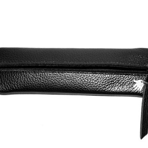 May include: A black leather pencil case with a zipper closure and a small silver charm.