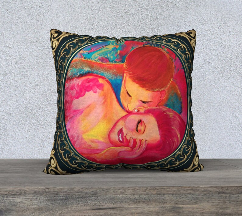 Puede incluir: Una almohada colorida con una pintura de dos personas abraz&aacute;ndose. La pintura est&aacute; enmarcada con un dise&ntilde;o de nudo celta dorado sobre un fondo azul oscuro.