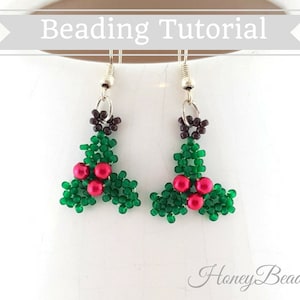 以下が含まれることがあります： 緑と赤のビーズでできた、ヒイラギの葉の形をしたイヤリングのペア。イヤリングはシルバーのフックにぶら下がっています。