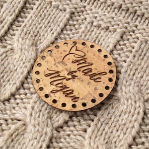 May include: A round, cork coaster with the words 'Made by Megan' written in cursive on it.