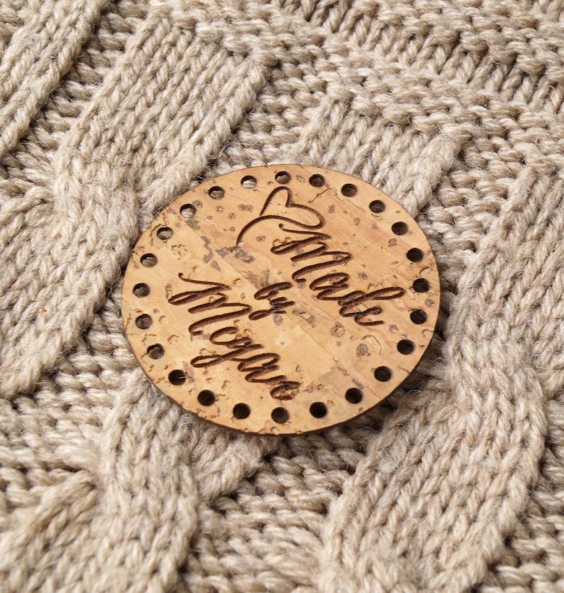 May include: A round, cork coaster with the words 'Made by Megan' written in cursive on it.
