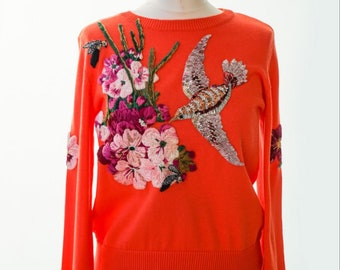 Orange sweater with embroidered flowers birds and bees