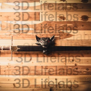 May include: A black sword with a silver hilt and a wolf head pommel is mounted on a wooden wall. The wall is made of light brown wood planks.