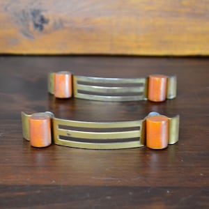 May include: A white ceramic mug with a black handle and the text "But First, Coffee" in a bold, black font. The mug is set against a plain white background, highlighting its simple design.