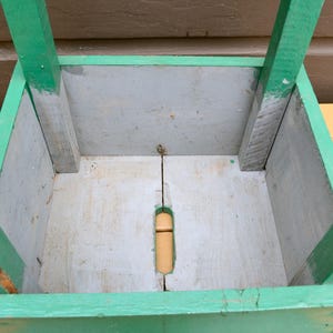 K&ouml;nnte beinhalten: Ein h&ouml;lzerner Pflanzkasten mit gr&uuml;ner Au&szlig;enfarbe und grauem Innenraum. Der Pflanzkasten hat eine rechteckige Form und ist aus Holz gefertigt.