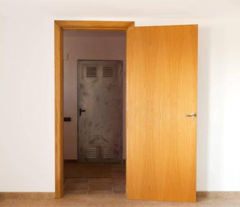 May include: A wooden door with a metal door behind it. Both doors have handles. The wooden door is light brown and the metal door is gray.